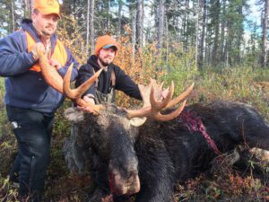 TWO PEOPLE WITH MOOSE HUNTING
